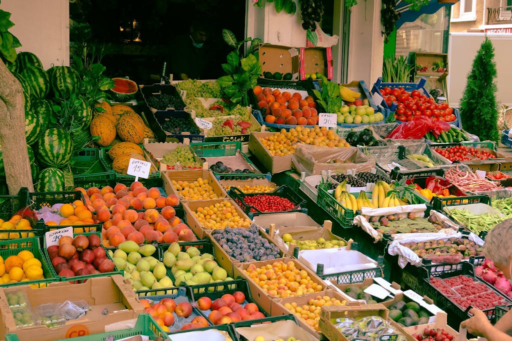 A colorful assortment of fruits and vegetables at an outdoor farmers market stall.