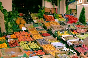 A colorful assortment of fruits and vegetables at an outdoor farmers market stall.