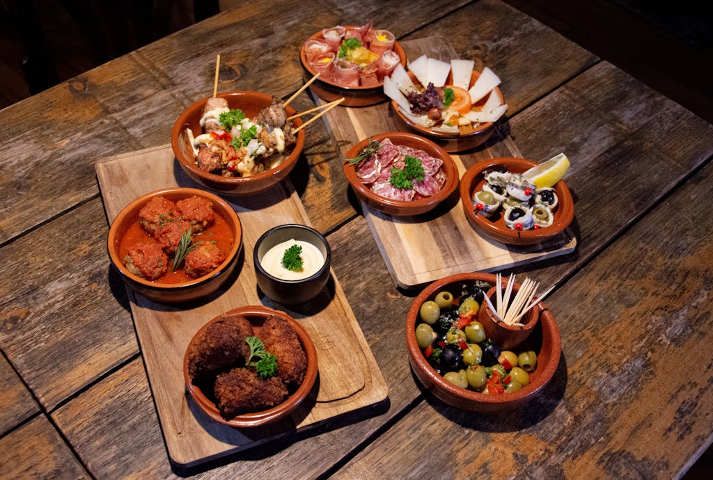A delightful assortment of traditional tapas served on rustic wooden boards for an appetizing meal.