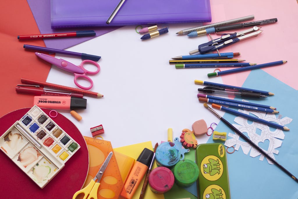 A vibrant selection of school supplies on a desk, including paints and stationery, ideal for creative projects.