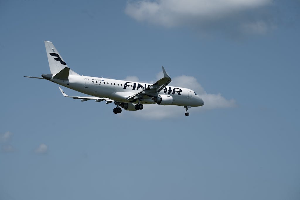 Finnair jet airliner in flight approaching Hamburg Airport on a clear day.