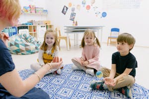 Happy children sitting indoors, enjoying fun learning activities in a kindergarten setting.