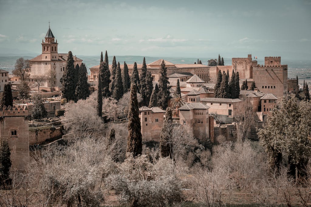 Scenic view of the historic Alhambra Palace surrounded by lush trees in Granada, Spain.