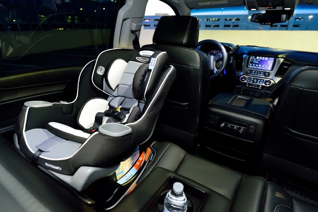 Interior of a car featuring a child safety seat and illuminated dashboard, captured at night.